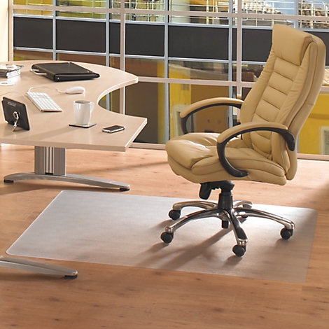 Beige bureaustoel voor bureau, raam op de achtergrond. Transparante vloerbeschermingsmat op houten vloer.