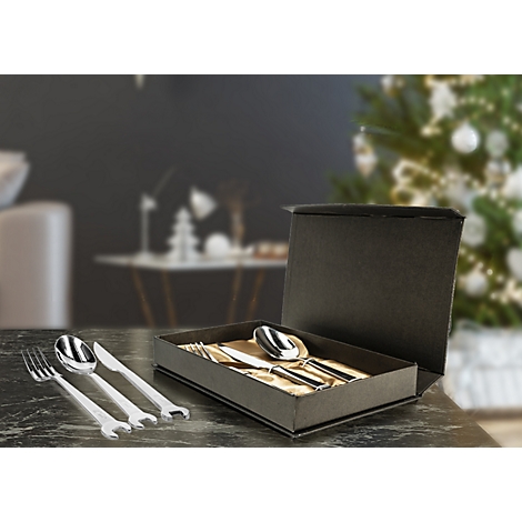 Besteckset in schwarzer Box, vor verschwommenem Hintergrund. Gabeln, Löffel und Messer glänzen.