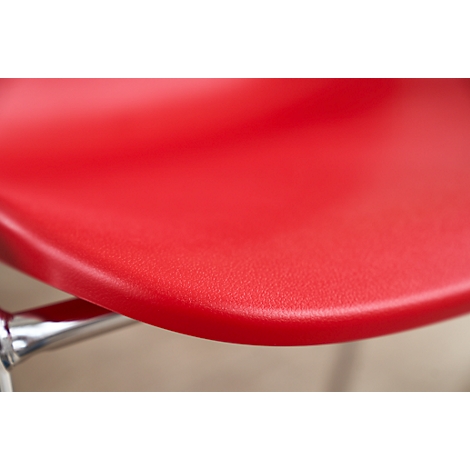 Close-up of a red chair. The seat is smooth and slightly textured.