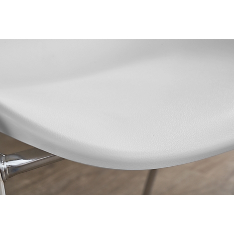 Close-up of a white chair seat with a silver metal leg. Wooden floor in the background.