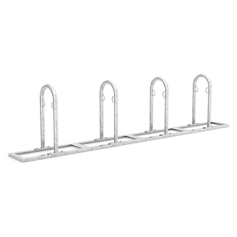 Metal bicycle rack with four U-shaped hoops. On a light background.