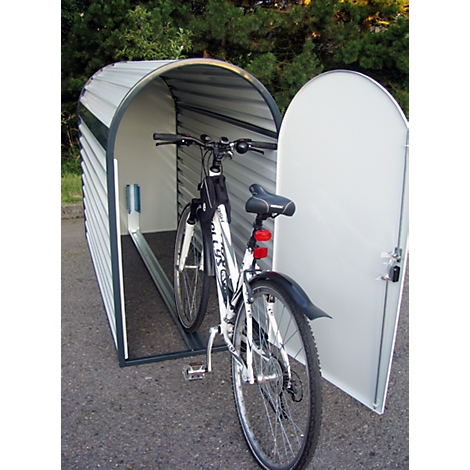 Bicycle parked in a white and gray bicycle garage with the door open.