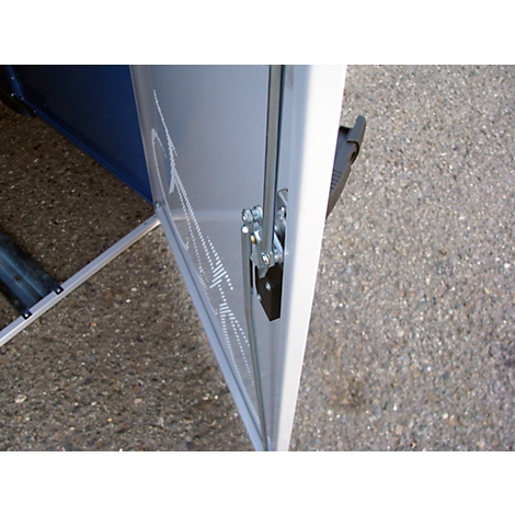 Close-up of a white door with metal hinge, behind it blue elements.
