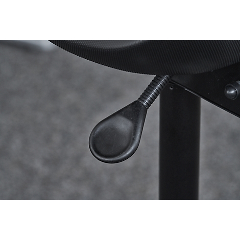 Close-up of the black, teardrop-shaped lever under a chair. Its position is attached to a corrugated metal spring.