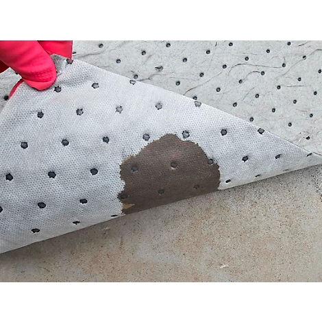 Blaues Absorptionsvlies, mit Öl bekleckst, wird von einer Hand mit rosa Handschuh gehalten.