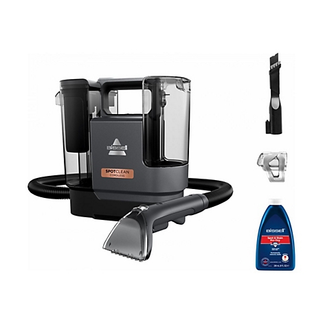 Drahtloser Bissell SpotClean Teppichreiniger mit Zubehör und Reinigerflasche.
