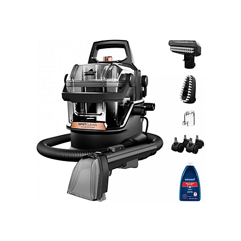 Ein schwarzer Bissell SpotClean HydroSteam Teppichreiniger mit Zubehör. Auf dem Foto sind eine Bürste, eine Düse und eine Reinigungsflüssigkeit zu sehen.