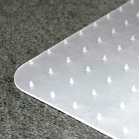 Nahaufnahme einer transparenten Bodenschutzmatte mit Noppen auf einem dunklen Teppichboden.