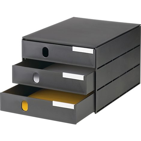 Meuble de rangement gris foncé avec trois tiroirs ouverts. Papier jaune dans le tiroir du bas.