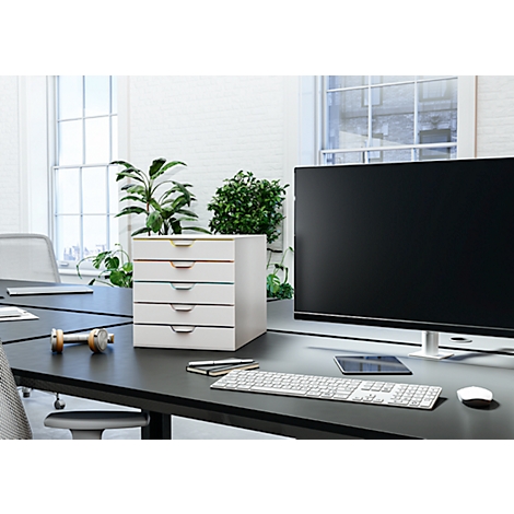 Bureau avec système de tiroirs blanc, moniteur, clavier, stylos et plantes.
