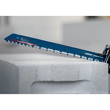 Eine blaue Säge schneidet durch einen weißen Porenbetonstein. Auf dem Sägeblatt steht 'CARBIDE TECHNOLOGY'.