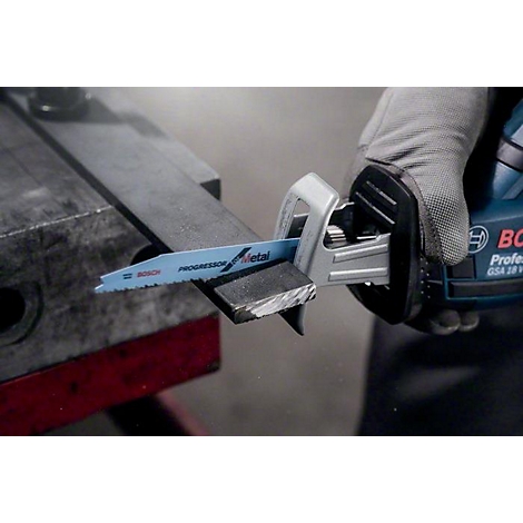 Eine Person schneidet mit einer Stichsäge ein Metallstück. Die Säge ist blau und trägt den Aufdruck 'PROGRESSOR Metal'.