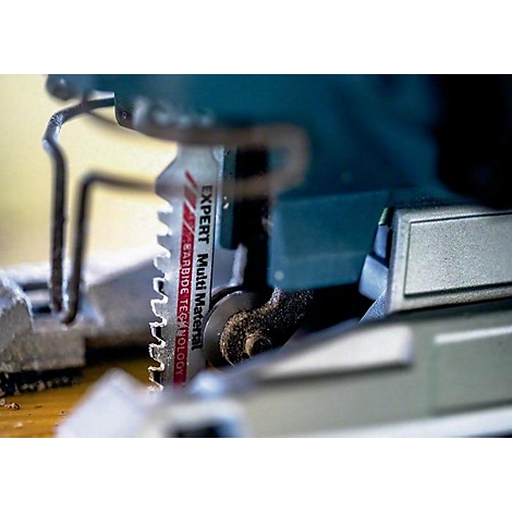 Nahaufnahme einer Stichsäge mit Sägeblatt. Auf dem Sägeblatt steht "Expert Multi Material" und "Carbide Technology".