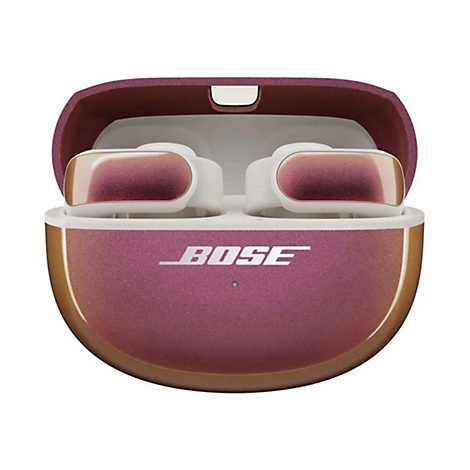 Geöffnetes Bose Ladecase mit metallisch schimmernden In-Ear-Kopfhörern in Pink und Gold vor weißem Hintergrund.