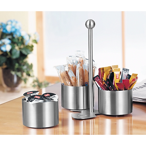 Stainless steel serving set with coffee pods, sugar and pastries. On a table.
