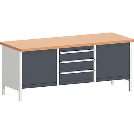 Een werkbank, lichtbruin tafelblad, grijze kasten, laden, zilveren handgrepen, witte poten.