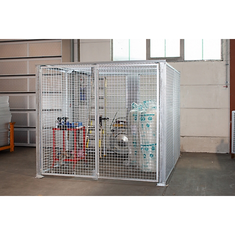Cage grillagée métallique pour bouteilles de gaz, sur fond clair. À l'intérieur, une table de travail rouge et noire.