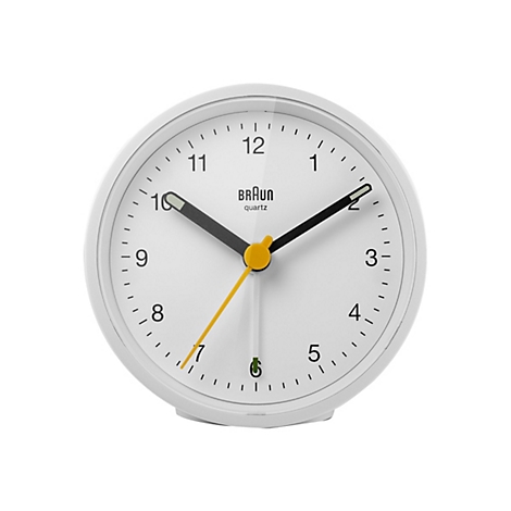 Weißer Braun Wecker mit schwarzem Ziffernblattdesign und gelbem Sekundenzeiger vor neutralem Hintergrund.