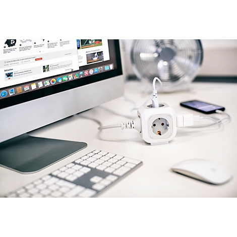 Cube de prise blanc, ordinateur, souris et smartphone sur un bureau.