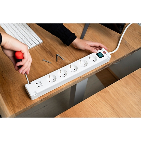Onder aanzicht van een lichtgrijze meervoudige contactdoos. Acht gaten en een kabel.