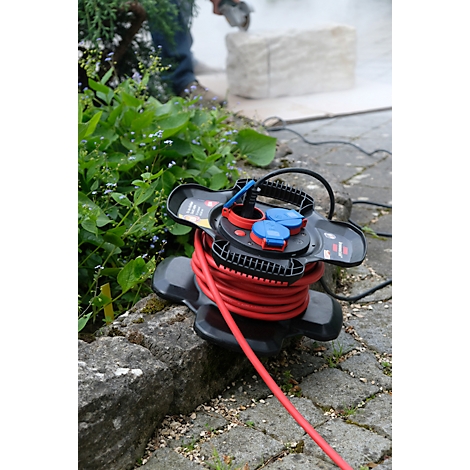 Une bobine de câble rouge est sur la pierre, à l'arrière-plan de la pierre est sciée.