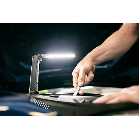 Un appareil cylindrique noir avec deux boutons ronds, un port USB et un renfoncement rectangulaire sur le dessus.