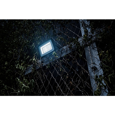 Detailaufnahme eines schwarzen Kabeleinführungsstutzens, der in eine dunkle Oberfläche eingeschraubt ist.