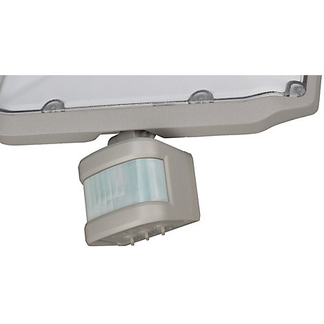 Close-up van een grijze buitenlamp met bewegingssensor. De sensor bevindt zich onder de lamp.