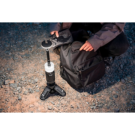 Une lanterne LED noire et cylindrique avec un élément lumineux blanc. Il y a des boutons et une bande grise sur le côté.