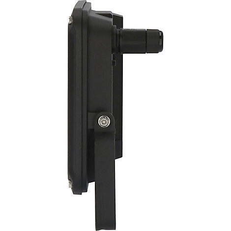 Ecke eines Gebäudes mit grauer Garagentür, weißer Wand und einer Lampe. Dach aus Holz und Metall.