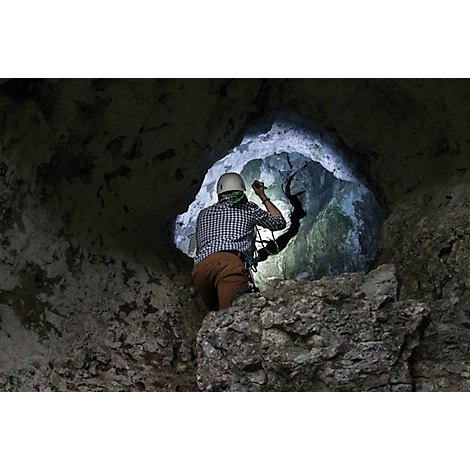 Schwarze Taschenlampe im Detail, gelbe Schutzkappe am Ladeanschluss, Metall-Clip und eingeprägte Kennzeichnungen.