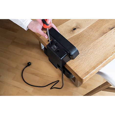 Instructions de montage. Lampe LED noire avec vis et flèches vertes indiquant la direction. Un fond gris.