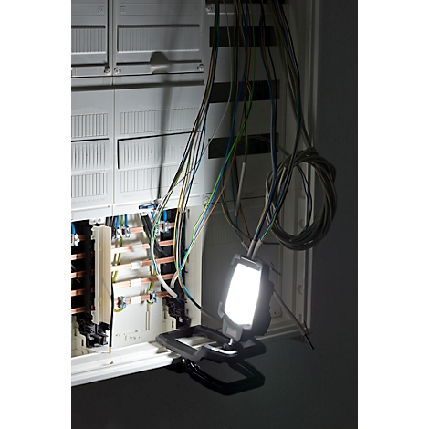 Elektrische zekeringkast, verlicht door een mobiele werklamp.