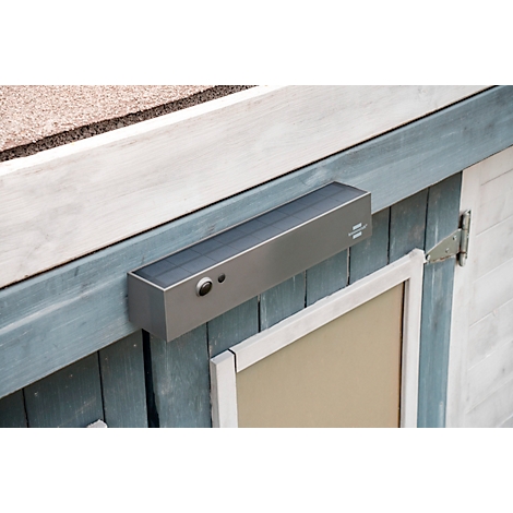 Ouvre-porte rectangulaire gris sur une porte en bois bleue, avec des boutons et une fenêtre.