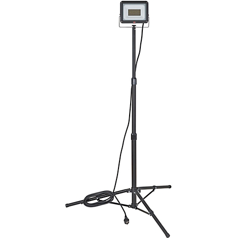 Schwarze Baustrahlerleuchte auf dreibeinigem Stativ. Das Kabel ist aufgerollt. Die Leuchte hat ein quadratisches Gehäuse mit vielen kleinen LEDs.
