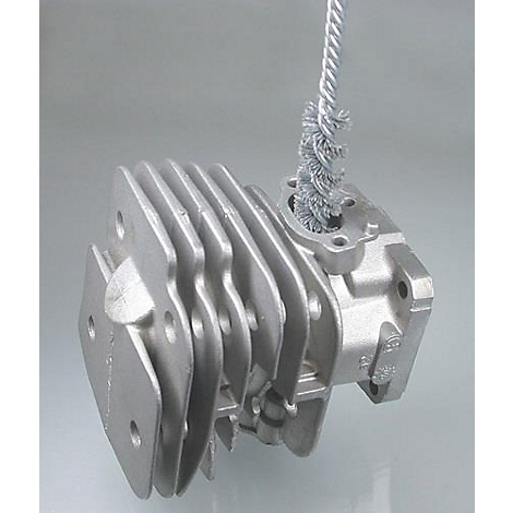 Une culasse argentée avec des ailettes de refroidissement, avec une brosse métallique attachée.