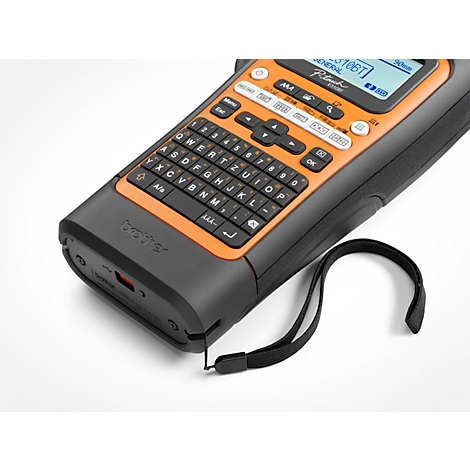 Gros plan d'une étiqueteuse Brother P-touch noire et orange. Petit clavier, écran et dragonne visibles.