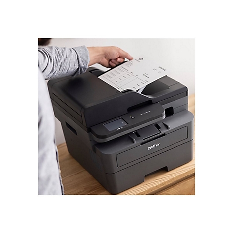 Ein Mann legt ein Rechnungsdokument in einen schwarzen Brother-Multifunktionsdrucker.