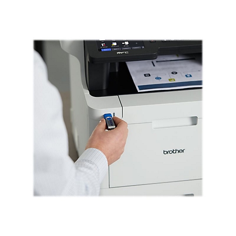 Eine Person hÃ¤lt einen USB-Stick an einem weiÃŸen Brother-Drucker. Ein Blatt Papier wird gerade gedruckt.