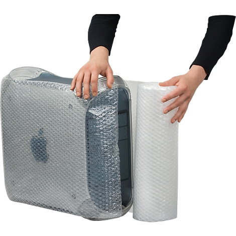 A person wraps a computer with bubble wrap for protection.