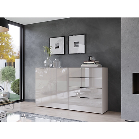 Buffet moderne de couleur crème contre un mur gris. Deux tableaux encadrés, des vases, des livres et une lampe sont également visibles.