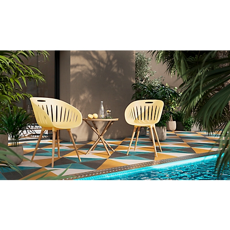 Twee gele stoelen staan voor een tafel, omringd door planten en een zwembad.