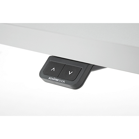 Gros plan sur les commandes d'un bureau réglable en hauteur électriquement. Boutons noirs avec des flèches et 'Schäfer Shor' en dessous.