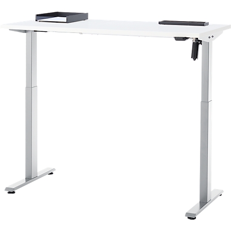 In hoogte verstelbaar wit bureau met zilveren poten. Op het tafelblad liggen een zwart opbergvak en een zwarte houder.