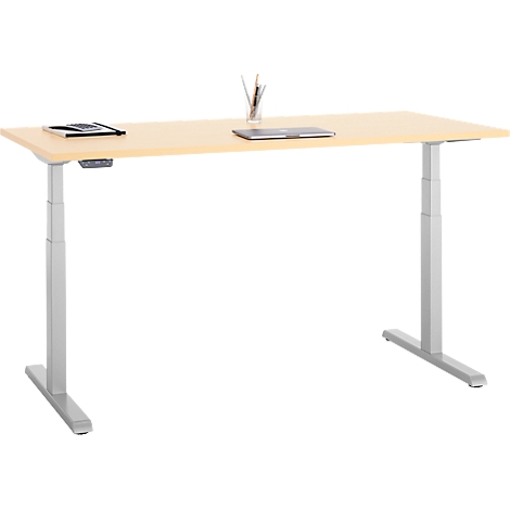 Een in hoogte verstelbaar bureau met een licht houten blad en zilveren poten. Pennen, een laptop en een notitieblok liggen bovenop.