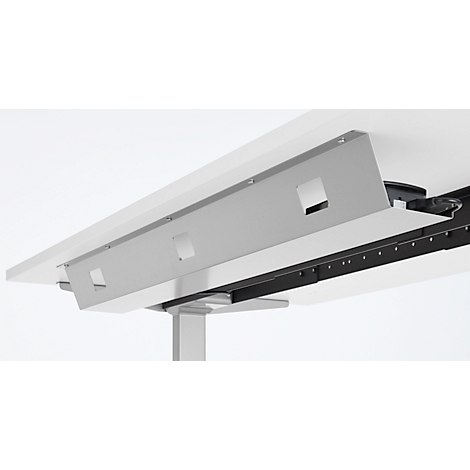 Gros plan sur un bureau blanc avec un panneau métallique gris comportant des découpes carrées, placé sous le plateau.