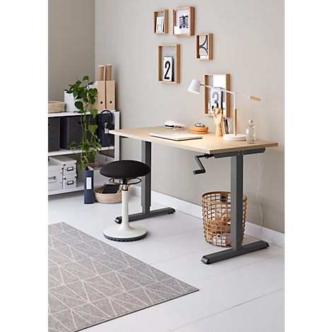Un bureau réglable en hauteur avec une chaise et des décorations comme des paniers et des photos sur le mur.