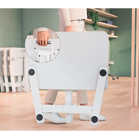 Personne portant une table blanche pliée. Vue détaillée montrant une poignée pour le transport.