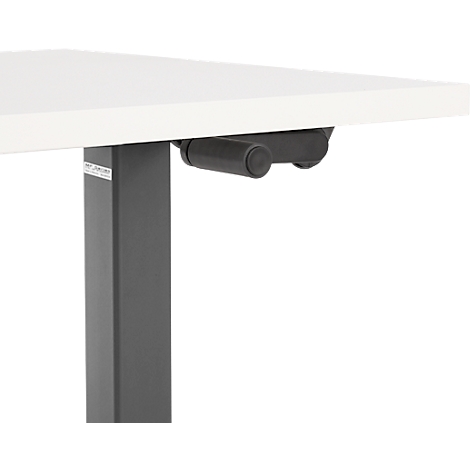 Détail d'un bureau réglable en hauteur. Commandes noires sous un plateau de table blanc.