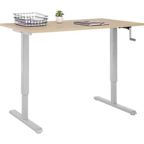 Bureau réglable en hauteur en bois clair. Panier, plante et carnet dessus. Avec manivelle pour le réglage en hauteur.